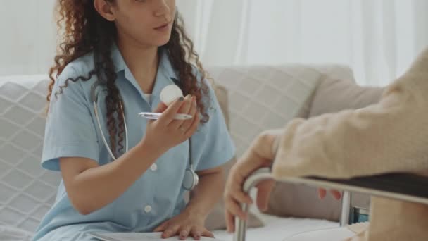 Нахилена Стійка Фокус Знімок Молодої Жінки Лікарки Дає Таблетки Старшій — стокове відео