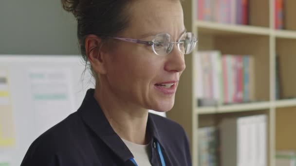 語学学校でレッスンをしながら話すことによって 女性英語教師のミディアムクローズアップショット — ストック動画