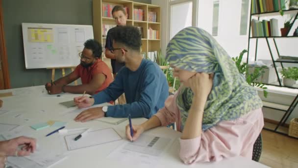 Grupp Multietniska Invandrarelever Sitter Vid Bordet Klassrummet Och Skriver Papper — Stockvideo