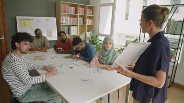 Kvinnan Håller Urklipp Och Förklara Lektion Samtidigt Undervisa Grupp Multietniska — Stockvideo