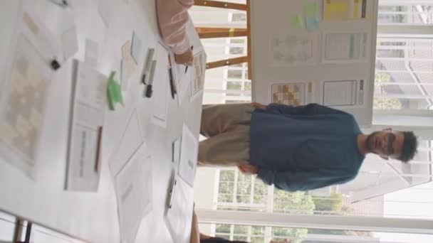 Вертикальный Снимок Молодого Мультирасового Мужчины Стоящего Доски Указывающего Бумажные Слайды — стоковое видео