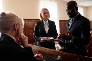 Savunma ve savcılık tarafları olgun kadın yargıcın önünde dururken Afrikalı Amerikalı avukat bazı noktaları açıklıyor.