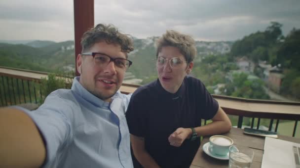年轻快乐的情侣们坐在山景咖啡馆里 看着相机 并通过在线视频通话聊天 — 图库视频影像