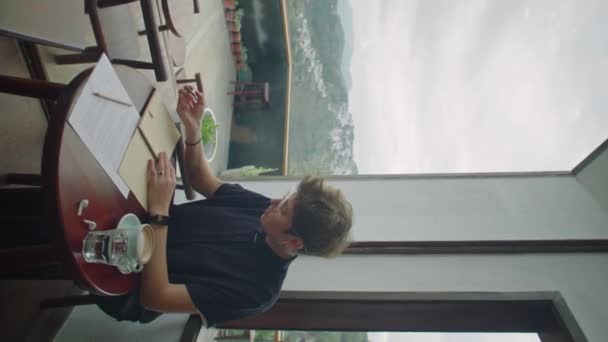 Tiro Vertical Una Joven Sentada Mesa Cafetería Pico Montaña Tomando — Vídeos de Stock