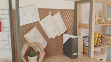 Marangozluk atölyesinde ahşap el sanatları ve enstrümanlarla birlikte masanın üstünde asılı duran alet ve kağıtların izini sürmek.