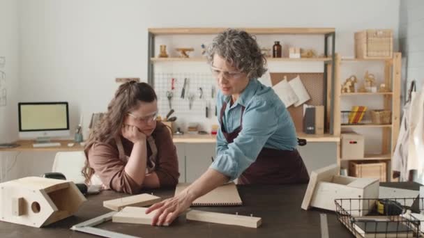 Kobieta Średnim Wieku Pracująca Drewnie Fartuchu Okularach Rysująca Papierze Rozmawiająca — Wideo stockowe