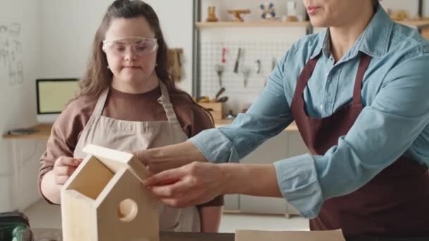 Dziewczyna Zespołem Downa Fartuchu Okularach Ochronnych Pomaga Nauczycielce Montażu Drewnianego — Wideo stockowe