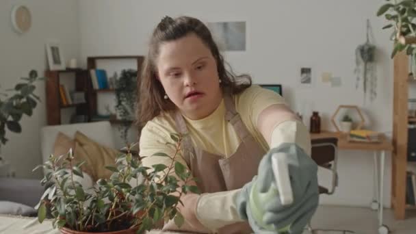 Meisje Met Syndroom Schort Handschoenen Spuiten Kamerplanten Met Water Van — Stockvideo