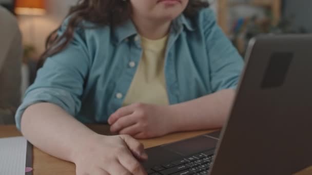 自宅でプライベート教師と学校のレッスンをしながらラップトップを使用してダウン症候群の少女のショットを傾倒 — ストック動画