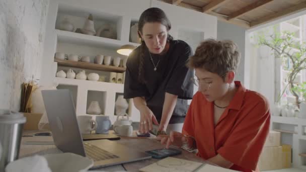 Medelhög Bild Två Kvinnliga Kollegor Som Använder Laptop Och Smartphone — Stockvideo