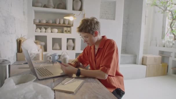 Mittlere Aufnahme Einer Jungen Keramikerin Mit Smartphone Während Ihres Arbeitstages — Stockvideo