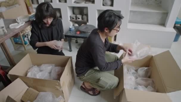Genç Asyalı Çömlekçilerin Yapımı Seramiklerini Müşteriye Göndermek Için Karton Kutulara — Stok video