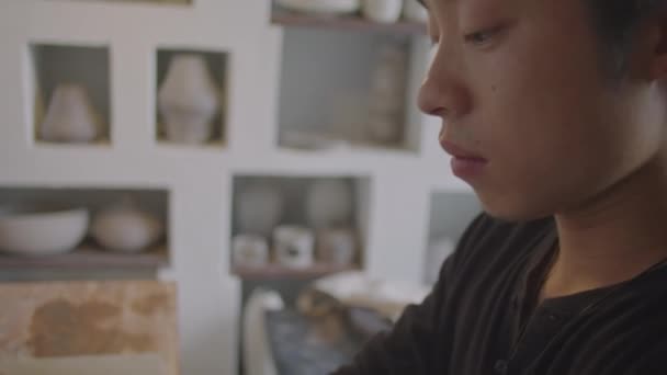 Umgeknickte Aufnahme Eines Jungen Asiatischen Keramikers Der Tagsüber Der Werkstatt — Stockvideo