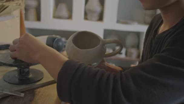 Junger Asiatischer Kunsthandwerker Arbeitet Töpferatelier Keramikbecher Mit Pinsel Und Schwamm — Stockvideo