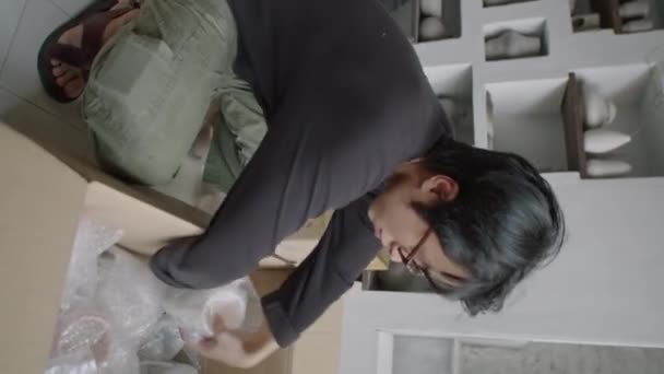 Vertikale Aufnahme Eines Jungen Asiatischen Mannes Beim Verpacken Handgemachter Keramik — Stockvideo