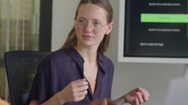 Genç Z 'li iş kadınının ofiste erkek meslektaşıyla tartışmasının net bir fotoğrafı.