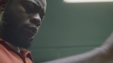 Berber dükkanında çalışırken erkek müşterinin saçını kesen konsantre siyah berberin yakın çekimi.