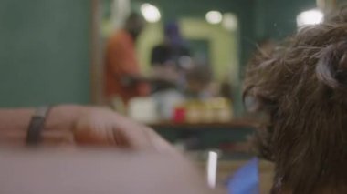 Saç makasıyla tanınmayan berberin yakın plan çekimleri ve müşterinin boynundaki kılları kesmek için tarak.