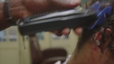 Erkek müşterinin yakasını budamak için saç makasıyla ve tarak kullanarak kişisel olmayan el çekimleri.