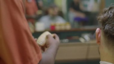 Afrika kökenli Amerikalı berberin erkek müşterinin ensesini budayarak kestiği seçici odak fotoğrafını yukarı kaldır.