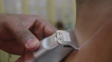 Berberin yakın plan çekimleri erkek müşterinin boyun kıllarını tıraş ederken jilet ve talk pudrasıyla.