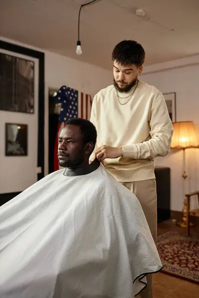 Vertical image of African American customer sitting in chair during his visit to barber shop