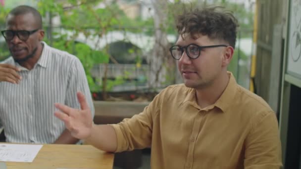 Młody Kaukaski Biznesmen Siedzi Przy Stole Tarasie Rozmawia Kolegami Podczas — Wideo stockowe