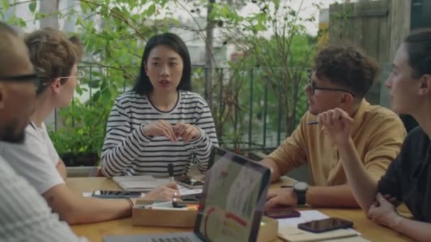 年轻的亚洲女商人在户外露台上与一群不同的同事交谈 — 图库视频影像
