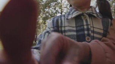 Pov 'da ellerinde kamera ve gülümseyen küçük kızlar yaz günü parkta kendilerini videoya çekiyorlar.