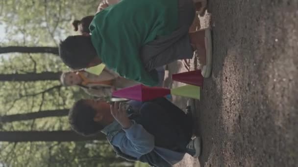 Tiro Vertical Meninos Meninas Sentados Chão Parque Empilhando Cones Plástico — Vídeo de Stock