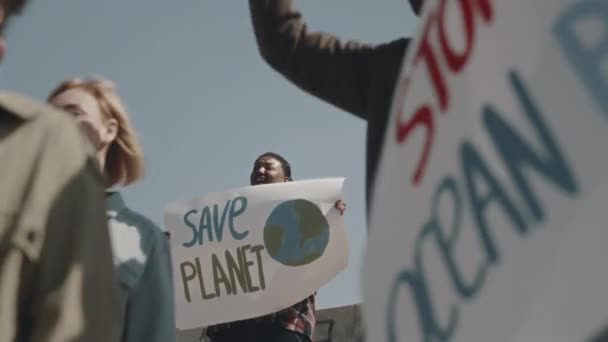 環境活動家の間で環境保護惑星のポスターに立っている若いアフリカ系アメリカ人女性 汚染に抗議 — ストック動画