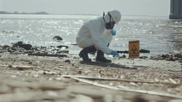 Эколог Защитном Покрытии Респираторной Маске Собирает Образец Почвы Загрязненном Берегу — стоковое видео