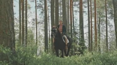 At üstünde oturan ve yaz günü ormanda at süren bir kız resmi.