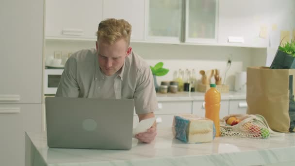 Tiro Medio Hombre Joven Apoyado Mesa Cocina Con Comestibles Lectura — Vídeos de Stock