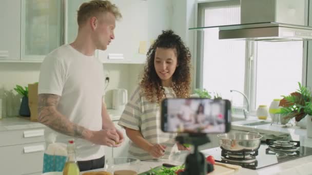 Medium Shot Van Jong Paar Stand Keukentafel Bespreken Ingrediënten Tijdens — Stockvideo