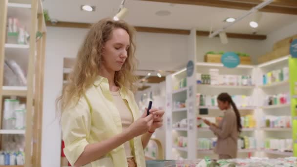 Kozmetik Mağazasından Alışveriş Yaparken Ruj Seçen Kadın Müşterinin Orta Boy — Stok video