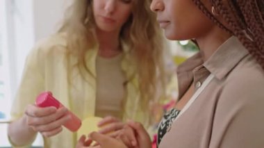 Mağazadan kozmetik ürünler alırken saç spreyini tartışan çeşitli kız arkadaşlarını aşağı doğru çek