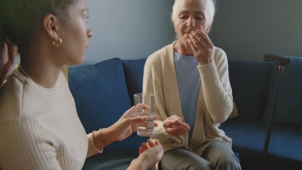 Tilt Shot Elderly Woman Taking Pills Drinking Water Assistance Young — Vídeo de stock