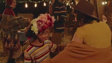Sıcak bir kasım akşamı arka bahçede Ölüler Günü 'nü kutlarken orta boy Meksikalı aile dansı ve parti.