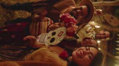 Geceleri arka bahçede Dia de Muertos 'u birlikte kutlarken, el yapımı neşeli Latin aile resimleri gülümsüyor ve el sallıyor.