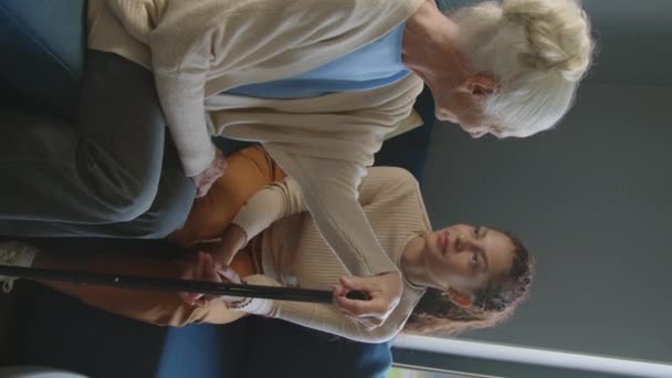 Вертикальный Снимок Пожилой Женщины Сидящей Диване Гостиной Разговаривающей Эмпатичной Сиделкой — стоковое видео