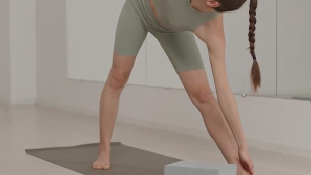 在健身演播室里 穿着运动服的年轻女瑜伽老师在课堂上展示三角形伸展姿势时的倾斜镜头 — 图库视频影像