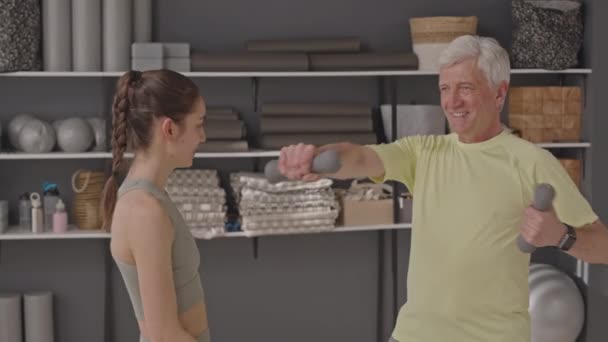 Jonge Vrouwelijke Fitness Instructeur Helpen Oudere Man Doen Halter Stoten — Stockvideo