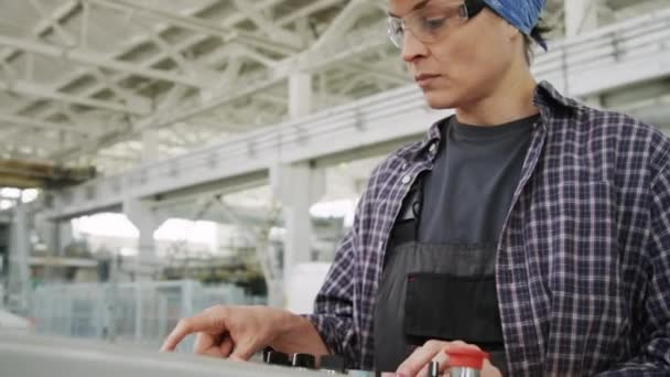 在工业厂房工作时 使用机器安装硬帽的专业女工程师的中档镜头 — 图库视频影像