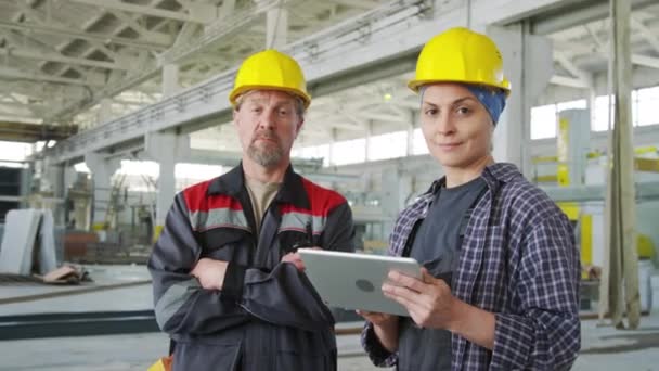 工业工厂女工程师拿着数码平板电脑与男同事合影的中景照片 — 图库视频影像