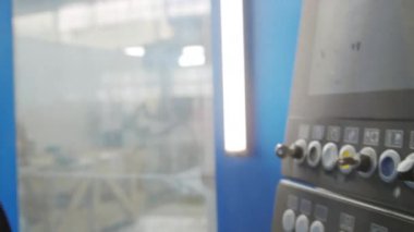 Fabrikada çalışırken kadın teknisyenlerin iş kıyafetlerini endüstriyel makine kullanarak yakın plan çekimleri.
