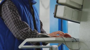 Fabrikada çalışırken kadın teknisyenlerin iş kıyafetleri ve kasketleriyle endüstriyel makineleri çalıştırma görüntülerini yukarı kaldır.