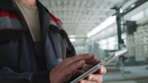 공장에서 일하는 주변을보고 디지털 태블릿을 사용하여 헤드셋을 착용하는 기술자의 기울이십시오 — 비디오