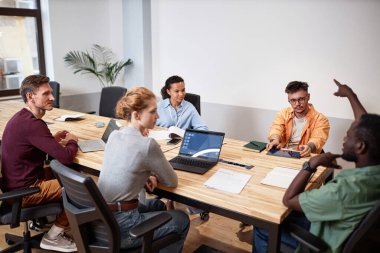 Toplantıda ekip halinde çalışırken bilgisayar kullanan bir grup iş adamı