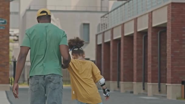 Вид Чёрного Мужчину Идущего Улице Поддерживающего Маленькую Дочь Пока Учится — стоковое видео